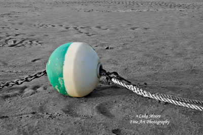 

Description

A turquoise and white boat mooring rests on a Cape Cod Bay sandbar during low tide on a summer evening. In this black and white seascape print, I used selective coloring to emphasize the colors on the buoy. A mooring chain and boat rope keep this buoy anchored as a lifeline for a sailboat. This photograph was taken in Brewster, Massachusetts MA Cape Cod New England.