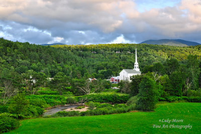The Stowe Community Church in Stowe, Vermont. This church surrounded by a lush and green, summer foliage and rustic mountains. The church is one of the most famous churches in Vermont and New England for that matter. In the distance, you can see parts of Main Street and Maple Street in Stowe. The Stowe town common is a quaint and charming little spot, a quite little slice of heaven. Town of Stowe is well know for its display of fall foliage colors during the autumn season. This Vermont landscape photograph shows how lush Stowe & Vermont can be during the summer. 